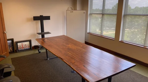 A large wooden table set in place in a meeting room
